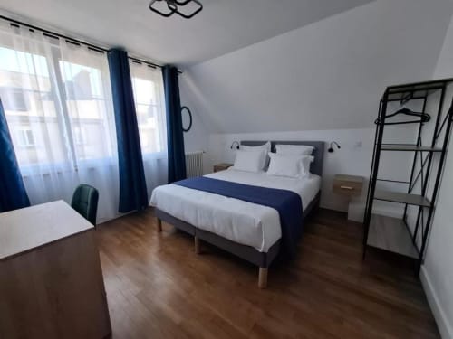 Superior King-Size bedroom at La Villa Cassinne in Montebourg with garden view, white bedding, wooden floor, and blue