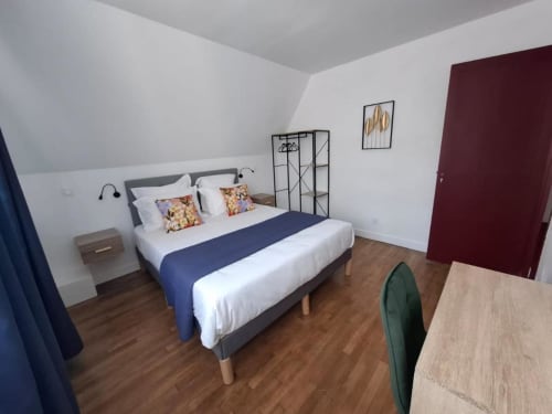 Modern bedroom at La Villa Cassinne B&B in Montebourg with bed, wood flooring, and white walls