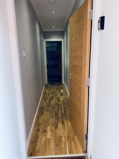 Modern hallway with wooden flooring and white walls at Whiteley's Cottages cottage in Dumbarton