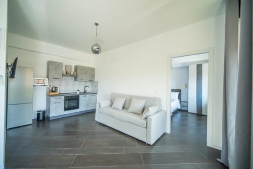 Appartamento Argiro Deluxe a Bari con cucina open space, soggiorno, divano e pavimenti in piastrelle scure