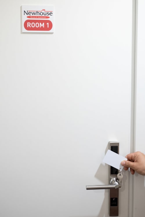 Mano che inserisce una chiave magnetica nella serratura elettronica dell'appartamento Newhouse Room 1 a Bari, Italia