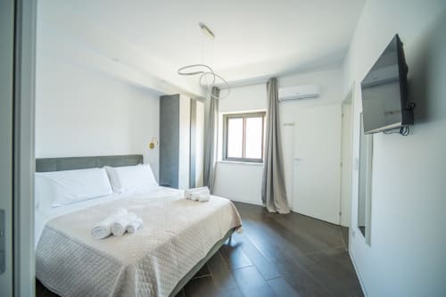 Camera moderna in Newhouse Argiro Deluxe Apartment, Bari con letto queen size, TV schermo piatto e vista sulla città