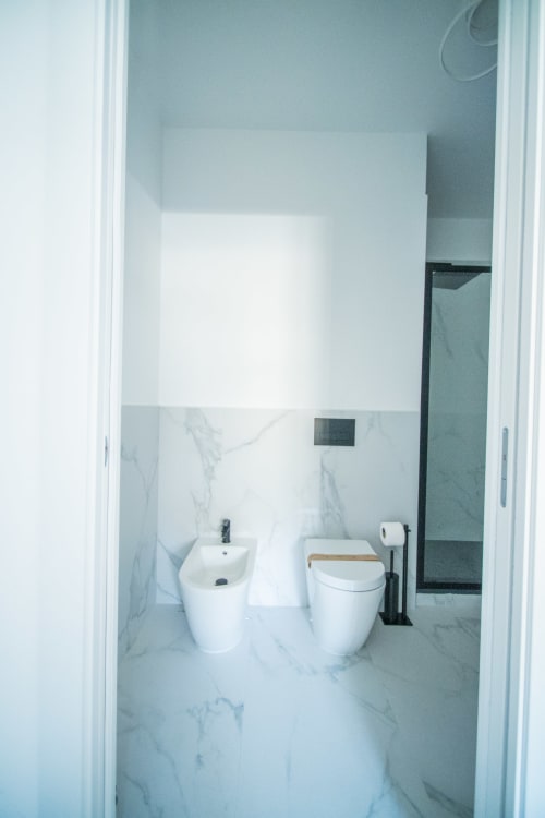 Bagno moderno nell'Apartament Deluxe Argiro del Newhouse hotel di Bari con pavimenti in marmo, sanitari bianchi e zona doccia