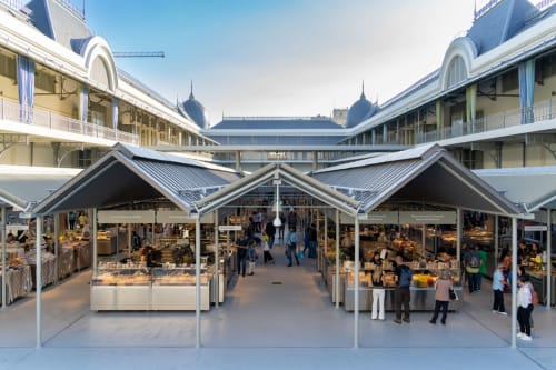 Pátio do mercado EcoHost em Matosinhos com barracas de vendedores, arquitetura clássica e clientes explorando produtos locais.