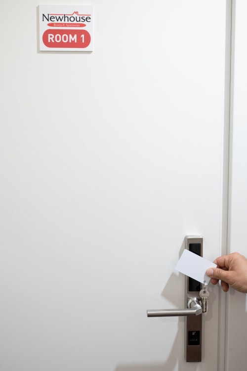 Mano che inserisce una tessera magnetica nella serratura elettronica della porta della camera 1 di Newhouse Hotel a Bari, Italia