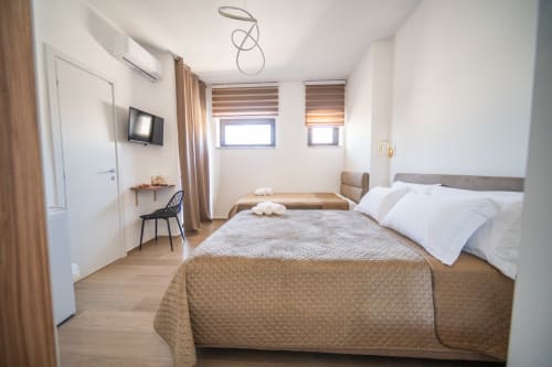Argiro Room 1 at Newhouse Bari - Modern bedroom with two beds, city view windows, wooden floors, and contemporary furnishings