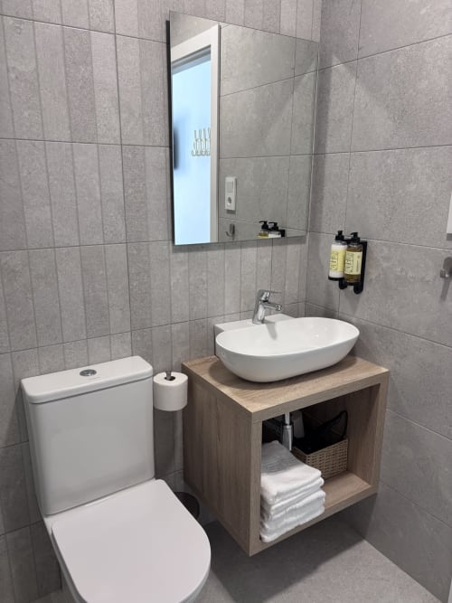 Modern bathroom in La Llar B&B, Carboneras with vessel sink, toilet, and tiled walls