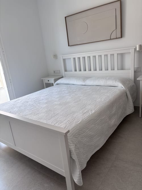 Modern white bedroom at La Llar B&B in Carboneras with double bed, sea view, flat-screen TV, and balcony access