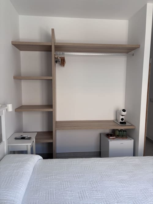 Modern wooden wardrobe with shelving in La Llar double room, Carboneras. Features storage and organizational hooks.