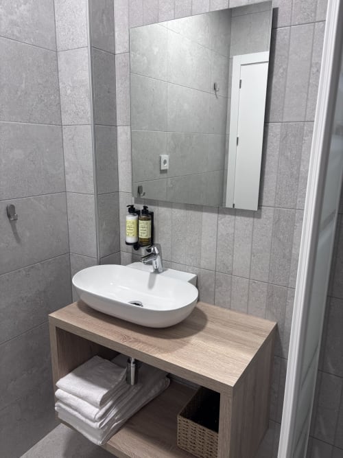 Lavabo moderno con pila blanca sobre encimera de madera en La Llar, Carboneras