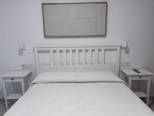 Dormitorio moderno y luminoso en La Llar con cama blanca, mesitas de noche y cabecero en Carboneras
