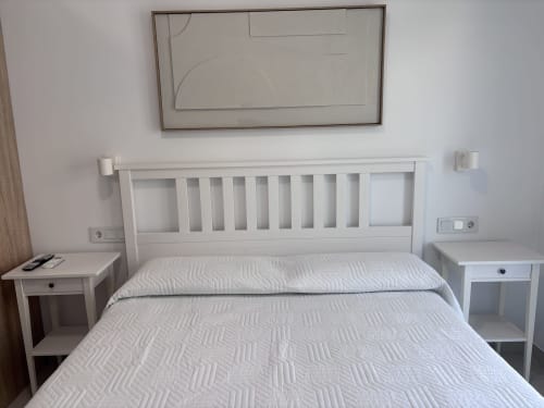 Modern white bedroom with double bed and slatted headboard at La Llar guesthouse in Carboneras, Spain