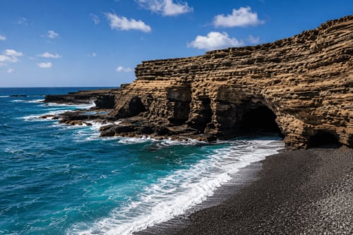 Acantilados costeros dramáticos y playa de arena negra en Hotel Rural El Cabo, Villaverde, España con aguas turquesas y olas blancas