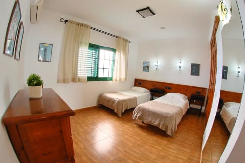 Luminosa habitación doble en Apartamentos La Palmera con muebles de madera, vistas al mar y comodidades modernas en La Frontera