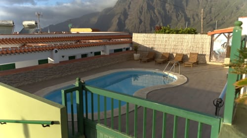Rooftop pool area at Apartamentos La Palmera in La Frontera with mountain views and lounge chairs