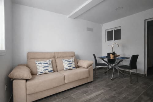 Modern living room in Apartamento Severo 1 at Alojamientos vacacionales en La Aldea with beige sofa, dining table, and white