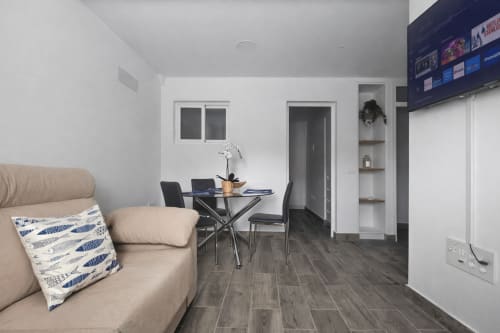 Modern apartment living area with beige sofa, dining table, and kitchen at Apartamento Severo 1 in La Aldea