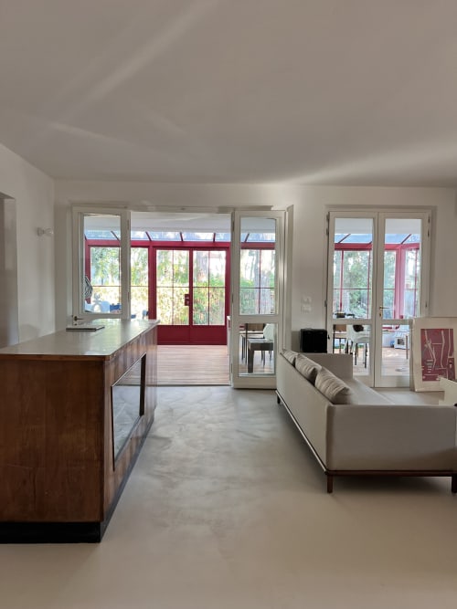 Modern open-plan living area at Casa Rossa villa in Marina di Campo with kitchen, seating, and sea view doors
