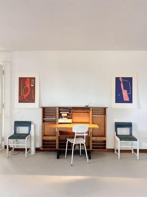 Modern home office setup at Casa Pineta villa with wooden desk, white chair, and abstract artwork on white walls