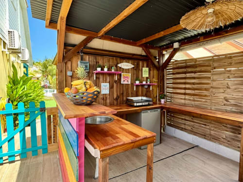 Cuisine extérieure à Kay Lakansiel, Le Vauclin avec comptoirs en bois, cuisinière et étalage de fruits tropicaux