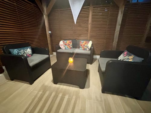 Lounge contemporain à l'hôtel Kay Lakansiel au Vauclin avec mobilier en rotin noir, coussins colorés et structure bois ajourée