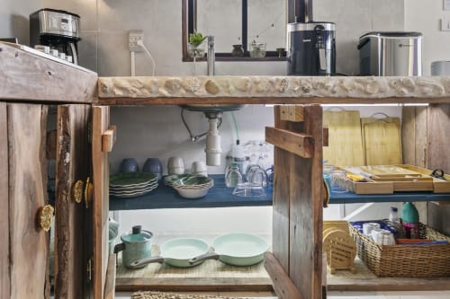 Rustic kitchen shelving with dishware, glassware, and cookware at Isla Mujeres apartment