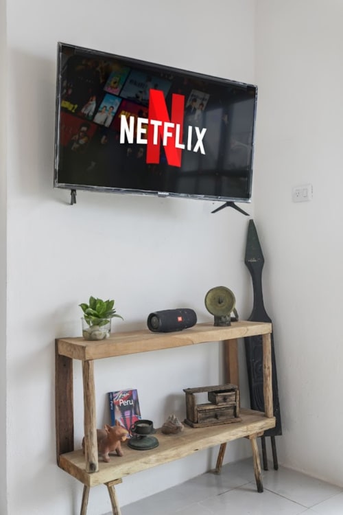 Netflix-enabled entertainment setup in Isla Mujeres apartment with wooden shelf and decorative accessories