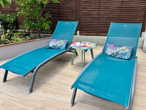 Deux chaises longues turquoise avec coussins à fleurs sur terrasse en bois à la villa Kay Lakansiel, Le Vauclin, Martinique