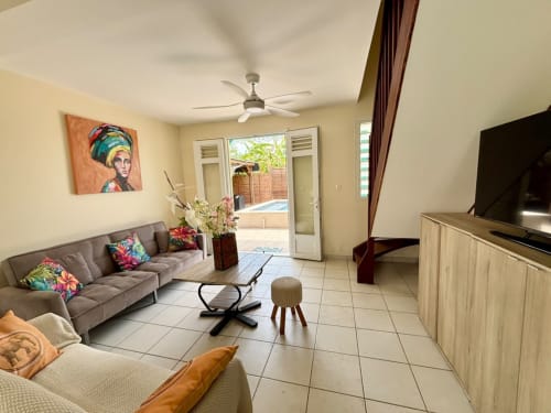 Séjour lumineux à la Villa Kay Lakansiel, Le Vauclin avec canapé gris, carrelage, ventilateur et décoration tropicale