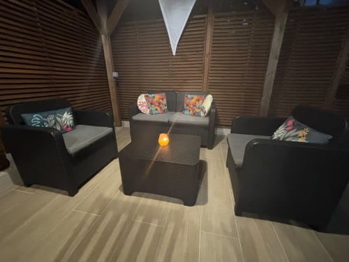 Espace de détente extérieur moderne de la villa Kay Lakansiel à Le Vauclin avec mobilier en rotin noir et coussins colorés