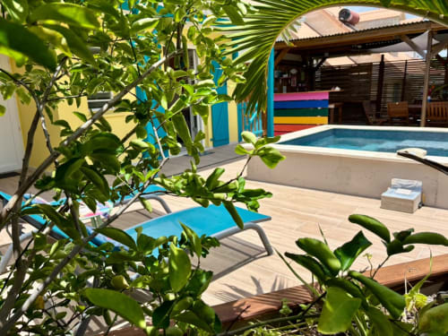 Villa tropicale avec piscine, bains de soleil, végétation luxuriante et bâtiments colorés à Kay Lakansiel, Martinique