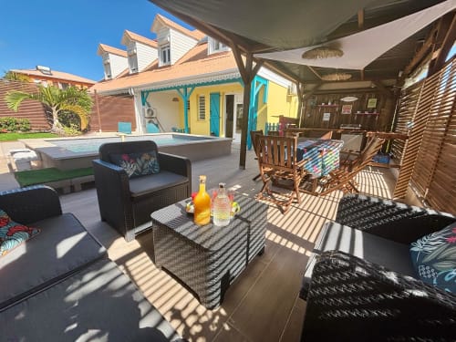 Terrasse ombragée de la villa Kay Lakansiel en Martinique avec coin détente, vue sur la piscine et décor tropical