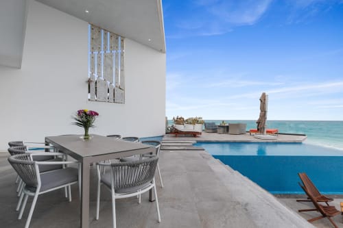 Modern beachfront villa dining area with pool overlooking Caribbean Sea at Isla Mujeres resort