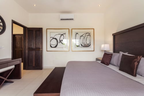 Elegant master bedroom in Casa Javi Ocean Front cottage on Isla Mujeres with king bed, dark wood furniture, and ocean view
