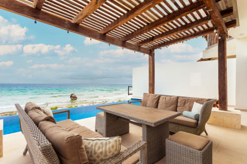 Beachfront patio with wooden pergola, wicker furniture, and ocean view at Casa Javi, Isla Mujeres