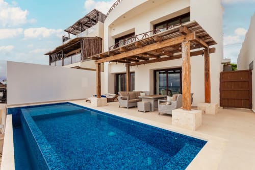 Casa Javi Ocean Front cottage in Isla Mujeres features a luxury swimming pool, wooden pergola, and ocean-view patio seating.