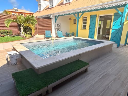 Piscine privée de la villa Kay Lakansiel au Vauclin, Martinique, avec maison jaune, volets turquoise et chaises longues.