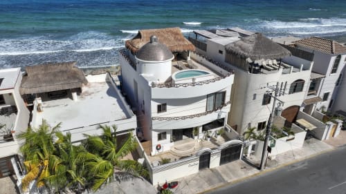 Oceanfront Casa Javi cottage in Isla Mujeres with white architecture, thatched-roof bungalows, pool, and Caribbean Sea views