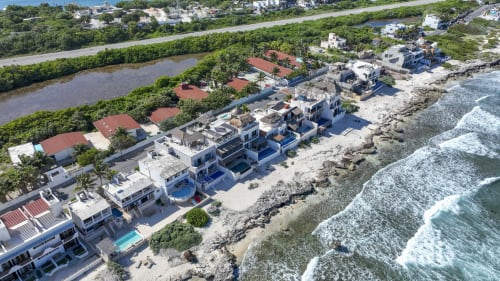 Oceanfront cottages in Isla Mujeres with white architecture, beach access, and Caribbean Sea views