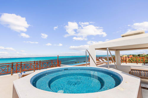 Circular blue jacuzzi overlooking turquoise Caribbean Sea at Villa Azul Maya, Isla Mujeres Mexico