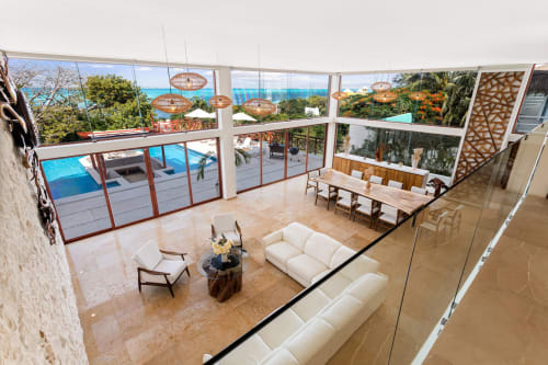 Luxurious Isla Mujeres villa interior with ocean views, infinity pool, modern seating, and tropical landscape