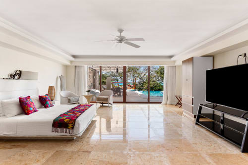 Luxurious villa bedroom in Isla Mujeres with sea view, pool access, modern amenities, and ocean-facing balcony