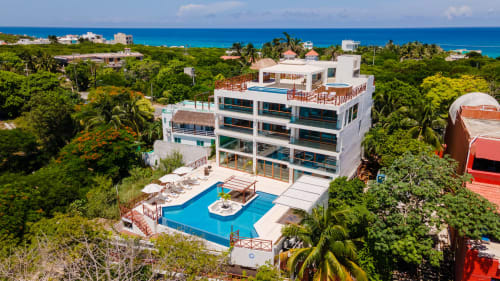 Modern beachfront villa in Isla Mujeres with pool, ocean views, and lush tropical vegetation