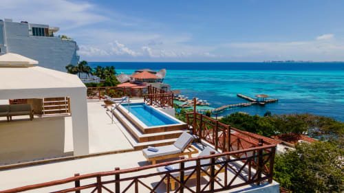 Villa Azul Maya oceanfront villa in Isla Mujeres with infinity pool, wooden terrace, turquoise Caribbean sea views, and