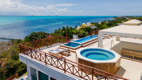 Luxury villa with oceanfront view, hot tub, and swimming pool overlooking turquoise Caribbean waters in Isla Mujeres, Mexico