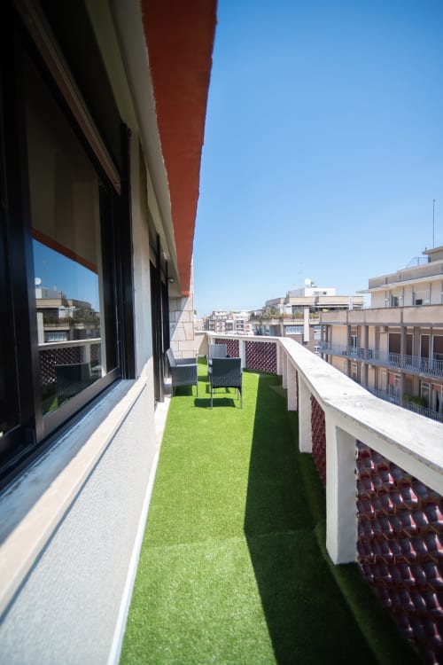 Terrazza panoramica Newhouse Bari con manto erboso sintetico, lettini e vista sulla città