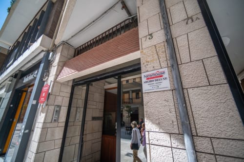 Ingresso dell'appartamento Newhouse Argiro Deluxe nel centro storico di Bari con facciata in pietra e moderna vetrina