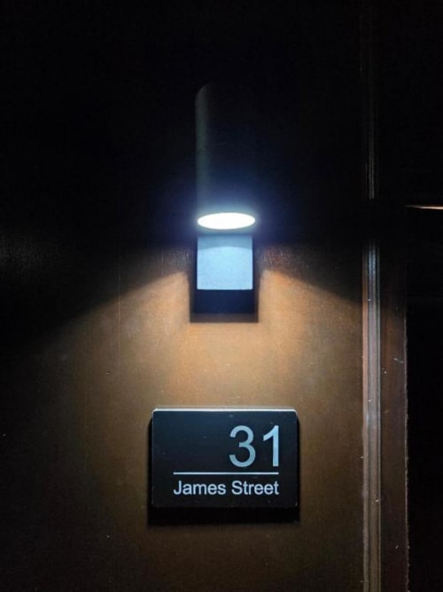31 James Street address plaque illuminated at night, The Courtyard by JS Apartments in Blackburn