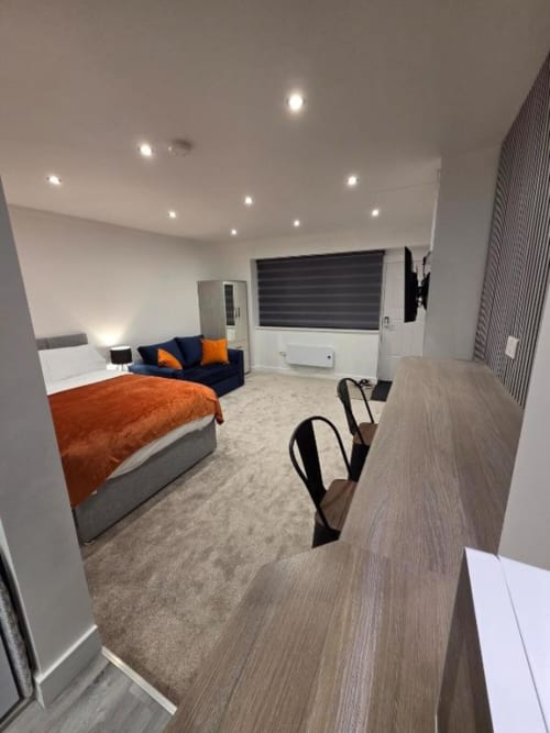 Modern studio apartment at The Snug by JS Apartments in Blackburn with bed, sofa, and kitchenette