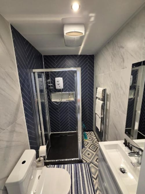 Modern bathroom in Spacious Suite at The Courtyard by JS Apartments, Blackburn, featuring black herringbone tiles and walk-in